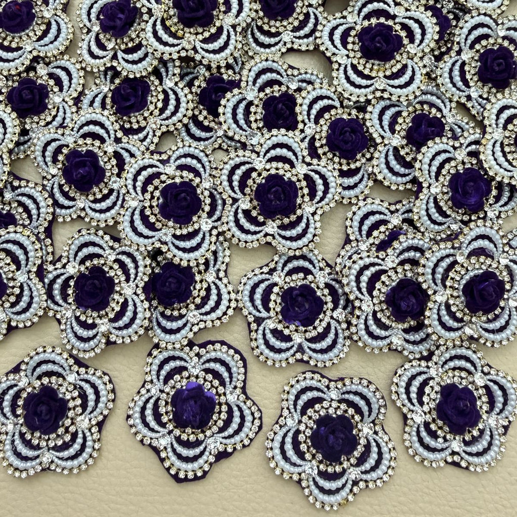 Purple rose flower patch with white pearl-look beads and clear rhinestones shown in hand