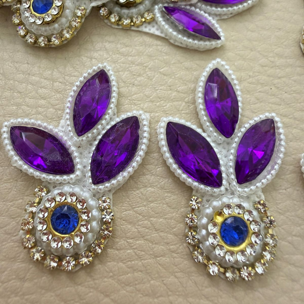 Purple leaf and blue stone patch held in hand showing pearl-look beads and clear stone detailing