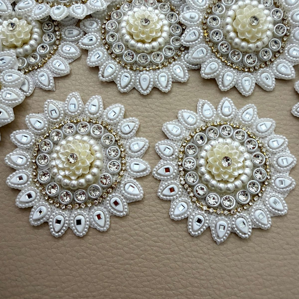 Ivory floral patch with pearl-look beads, clear stones and mirrored teardrop petals held in hand