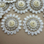 Ivory floral patch with pearl-look beads, clear stones and mirrored teardrop petals held in hand