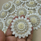Close-up of floral patches with clear stones and gold-tone border detailing