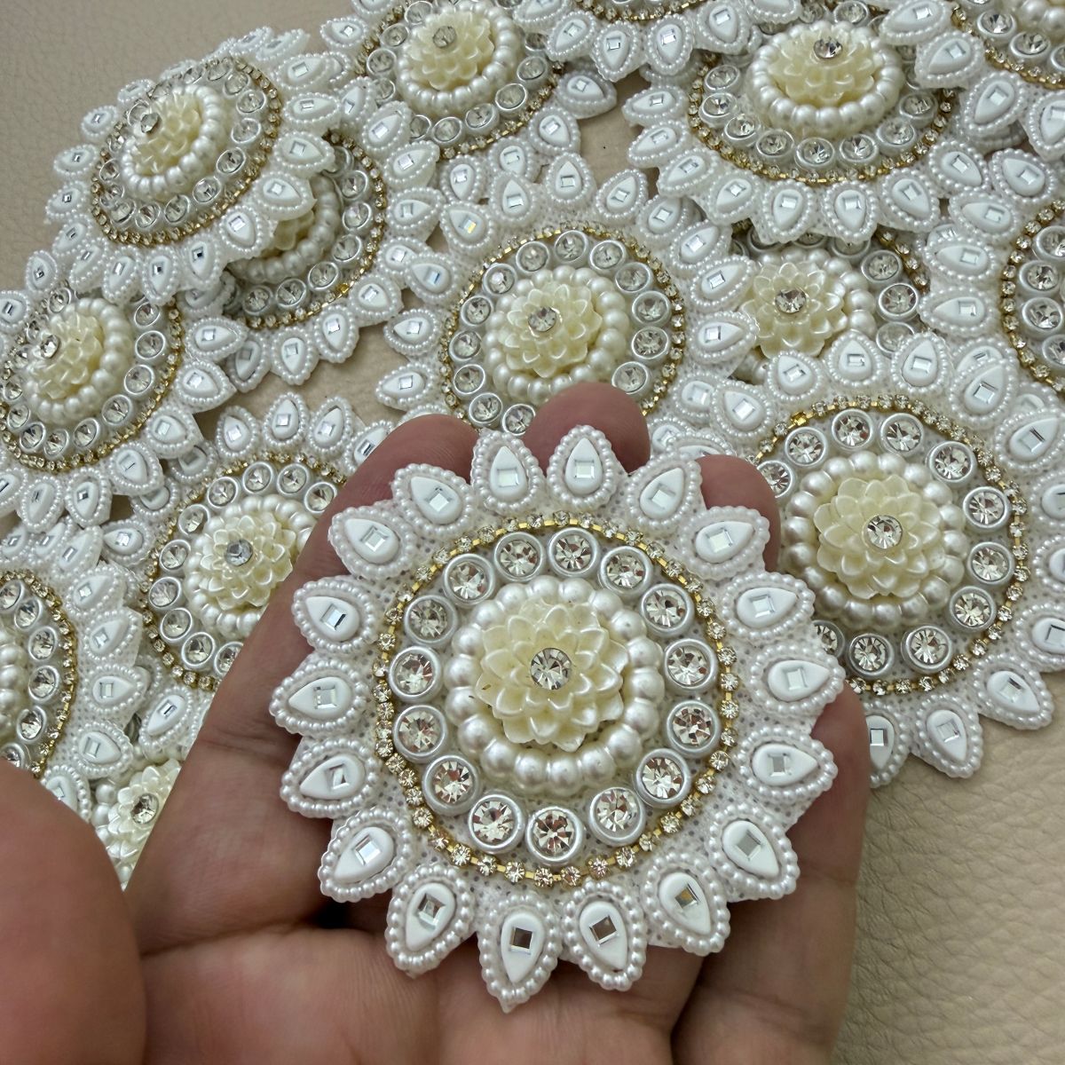 Close-up of floral patches with clear stones and gold-tone border detailing