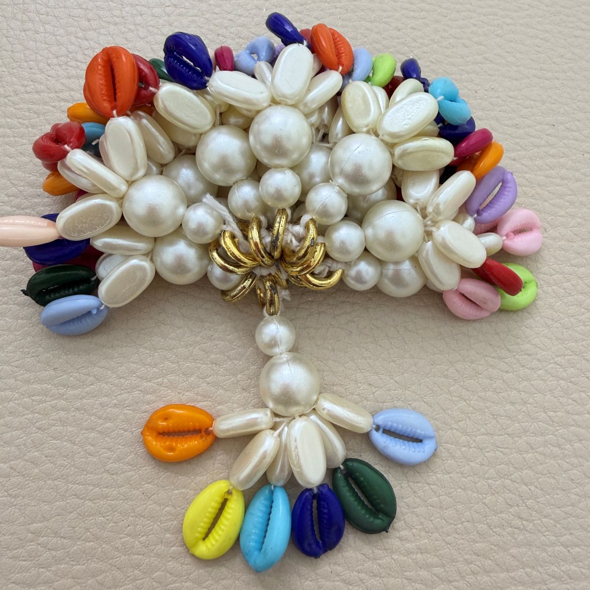 Multicolor kodi tassel shown in hand for scale