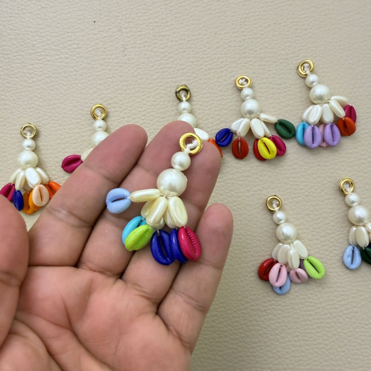 Ten assorted multicolor kodi tassels with white pearl-look beads and gold-tone rings