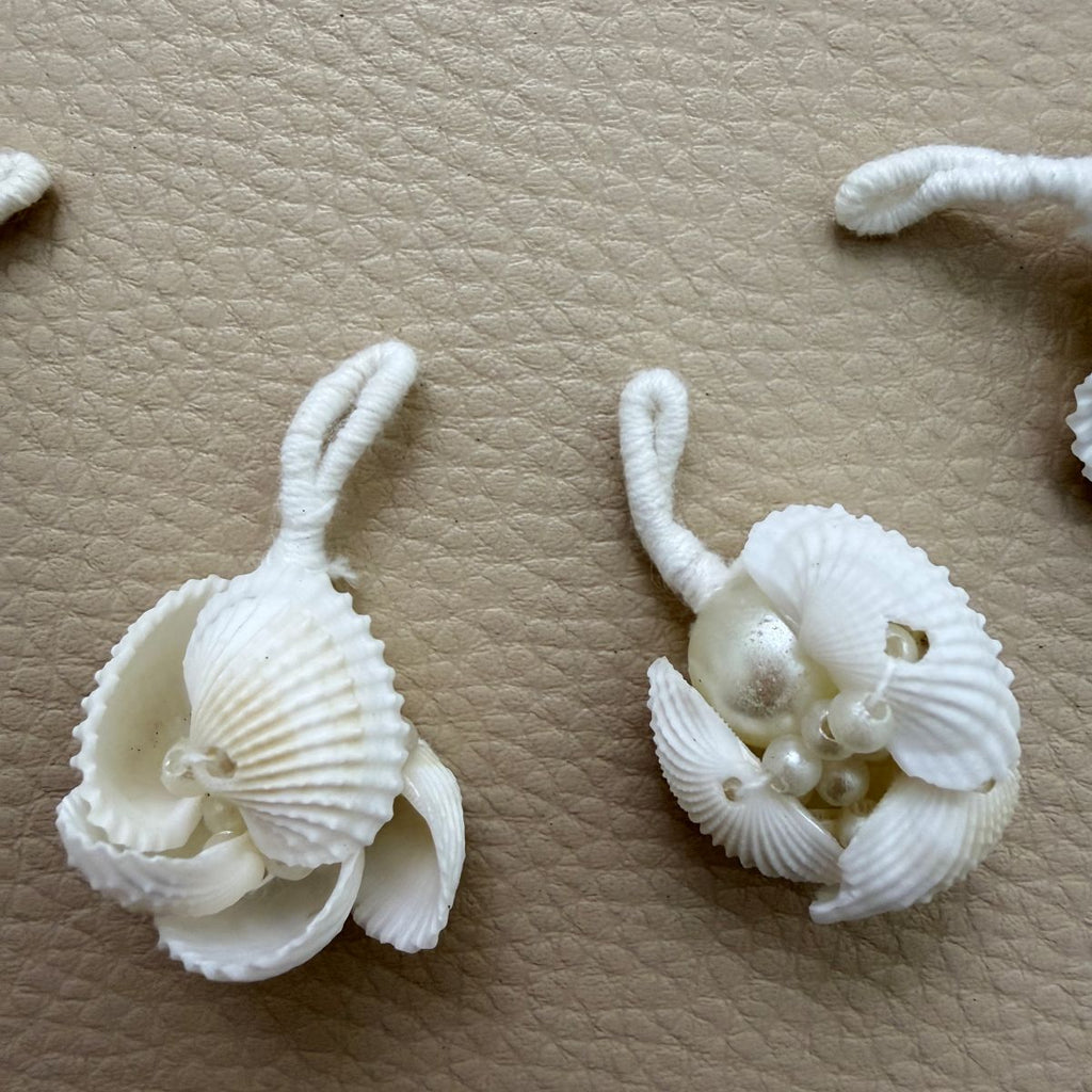Close-up of white shell tassels with pearl-look beads and thread-wrapped loops
