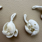 Close-up of white shell tassels with pearl-look beads and thread-wrapped loops