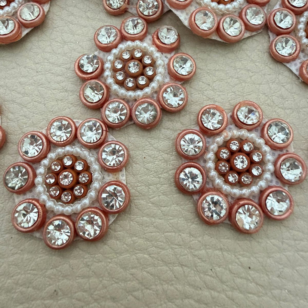 Peach copper rhinestone and pearl-style bead flower patch held in hand