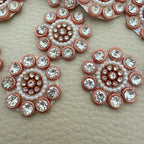 Peach copper rhinestone and pearl-style bead flower patch held in hand