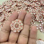Close-up of round peach copper rhinestone flower patches