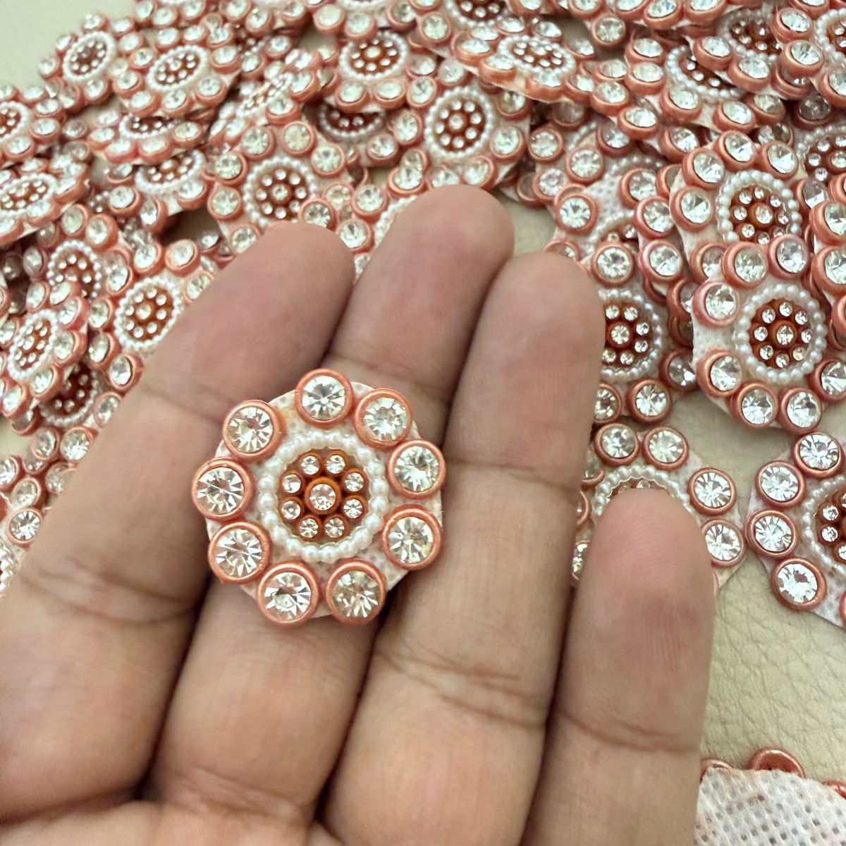 Close-up of round peach copper rhinestone flower patches