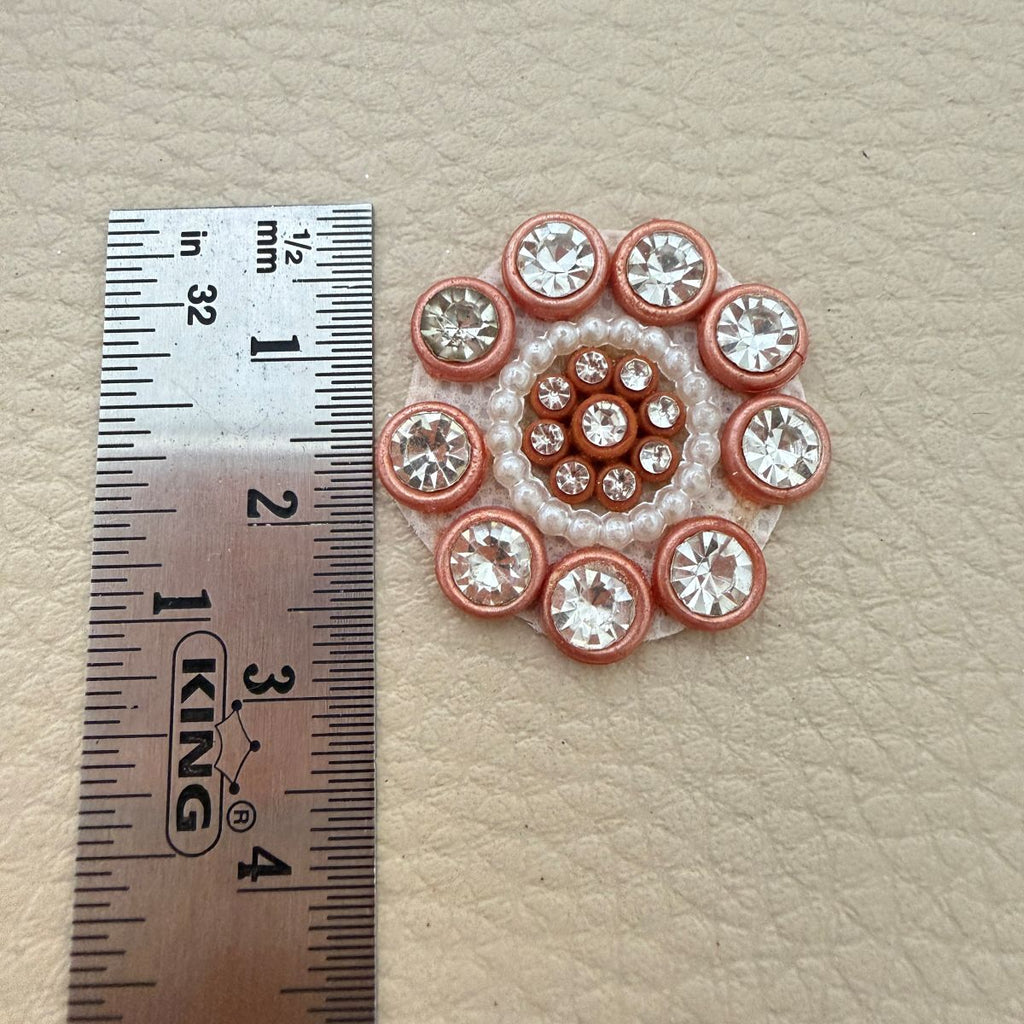 Flower applique beside ruler showing approximately 2.5 cm size