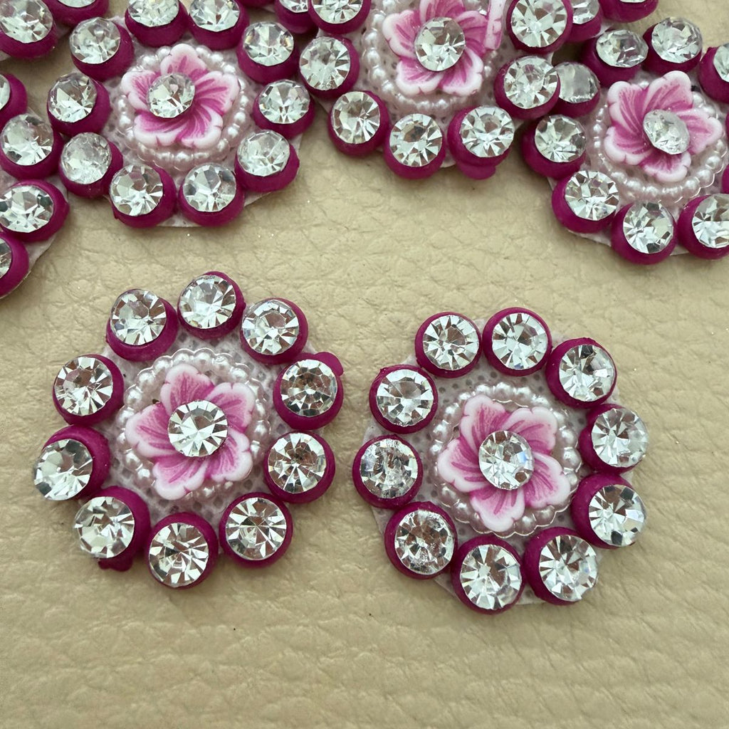 Pink flower rhinestone applique held in a hand