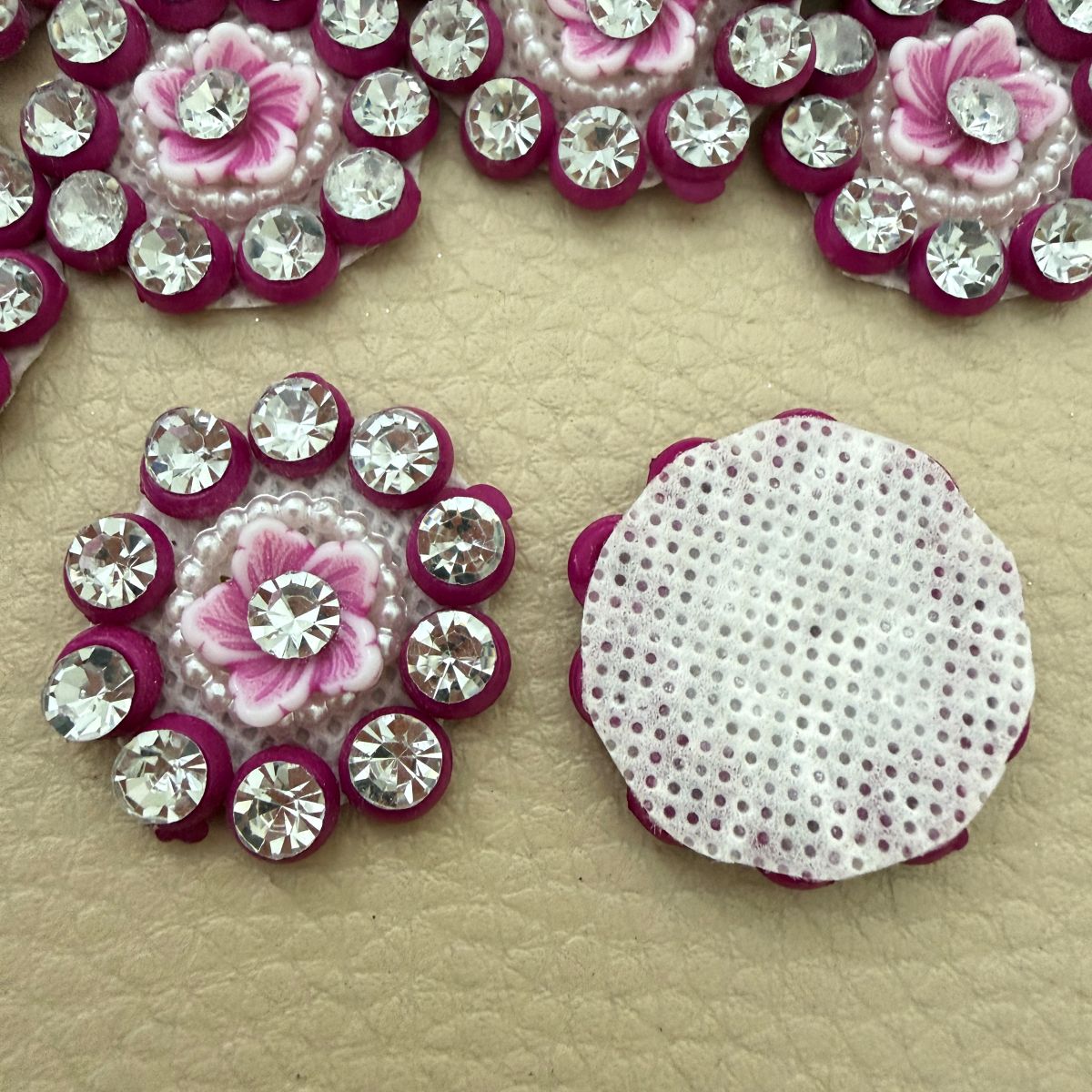Pink flower rhinestone applique beside a ruler showing approximately 3 cm size