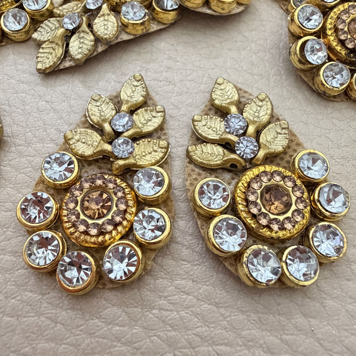 Close-up of gold leaf patches with clear rhinestones and champagne centers