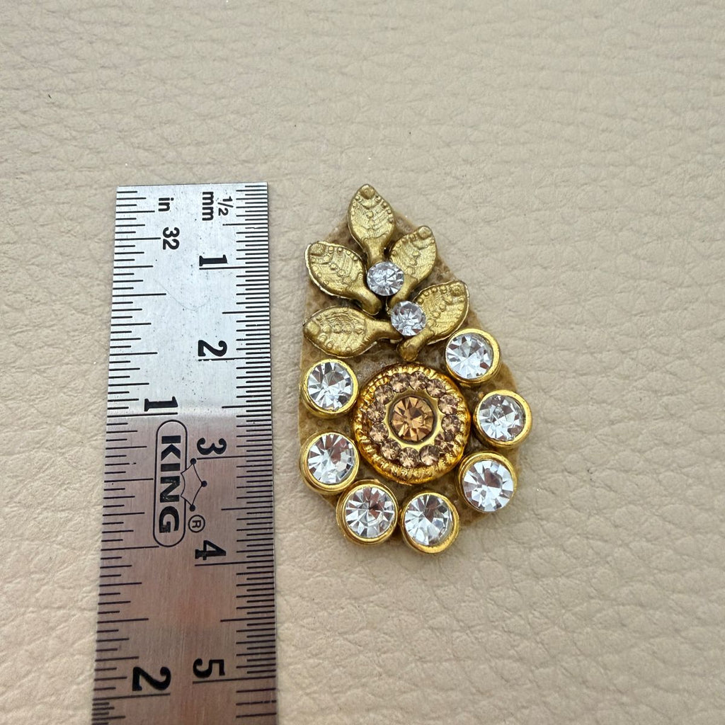 Gold leaf rhinestone applique beside a ruler showing approximately 4 cm length