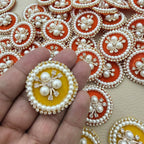 Close-up of orange and yellow pearl and rhinestone patches
