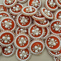 Orange round patches with ivory-coloured pearl beads and clear rhinestones