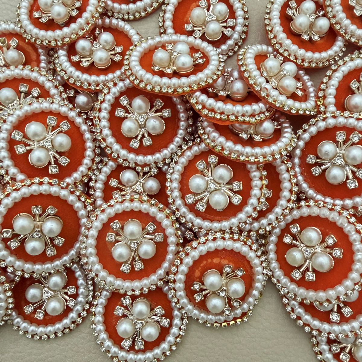 Orange round patches with ivory-coloured pearl beads and clear rhinestones