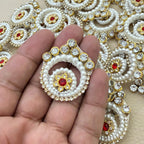Pearl and rhinestone spiral patch held in hand for scale
