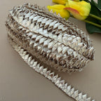 Decorative metallic ribbon with a textured pattern on a neutral background