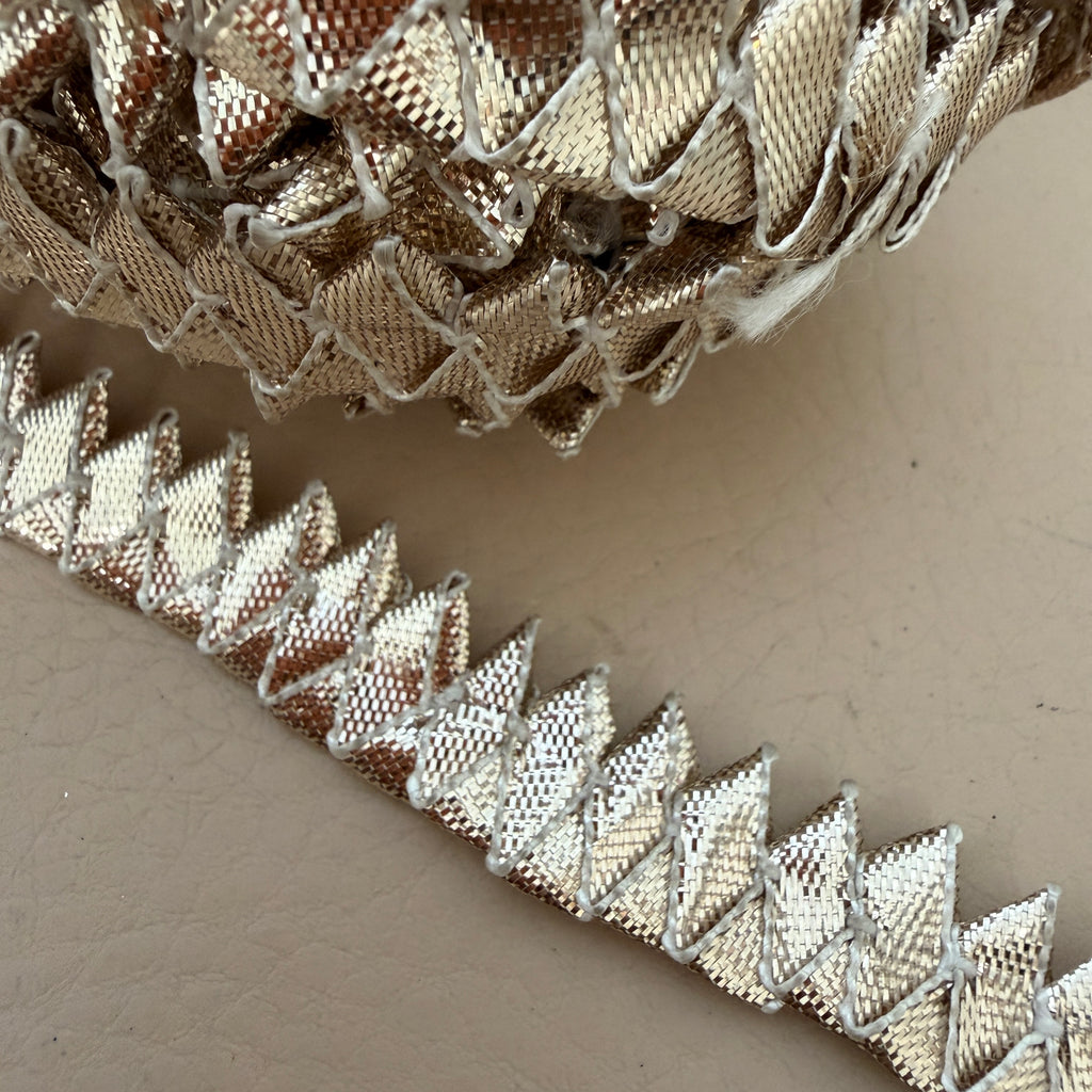 Close-up of decorative metallic trim on a neutral background