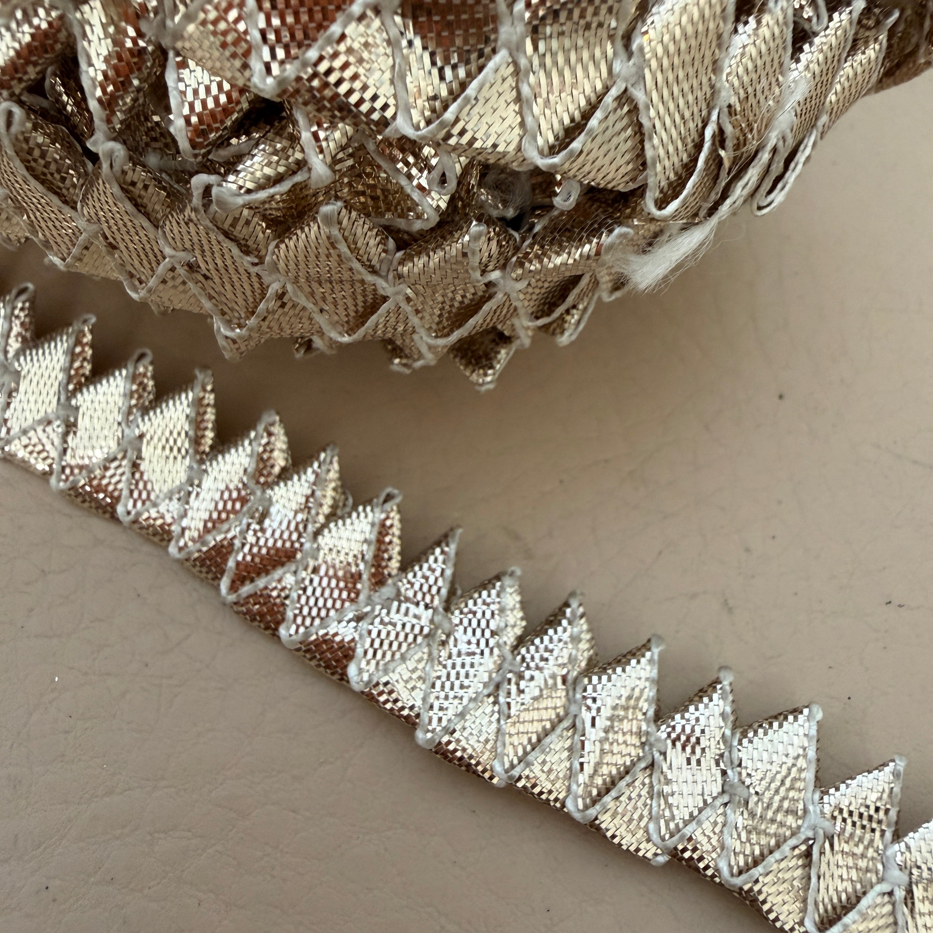 Close-up of decorative metallic trim on a neutral background