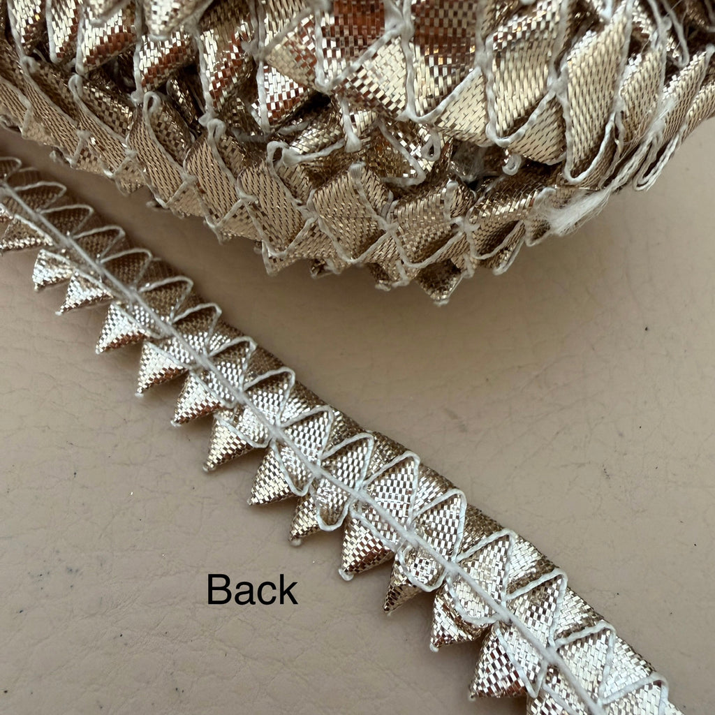 Close-up of metallic lace trim on a beige background