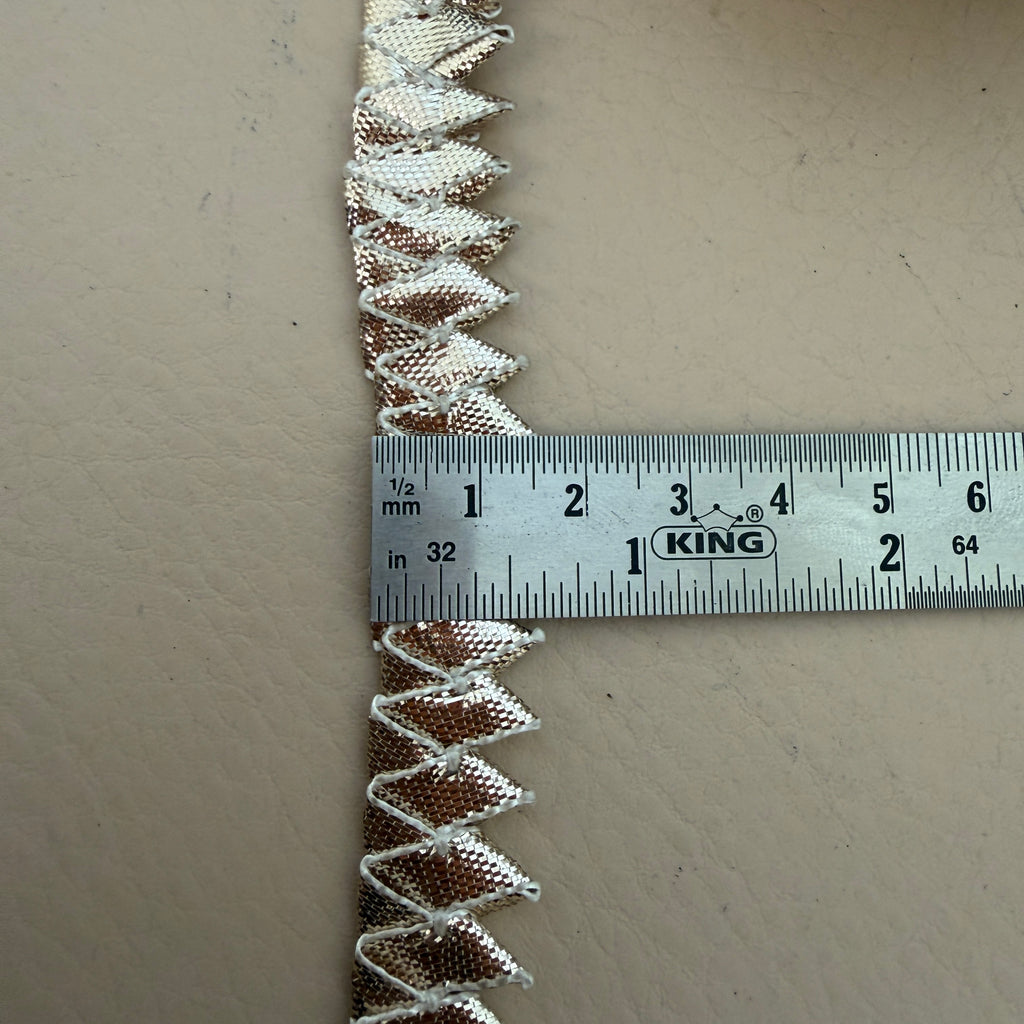 Decorative trim with a ruler for scale on a beige background