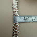 Decorative trim with a ruler for scale on a beige background