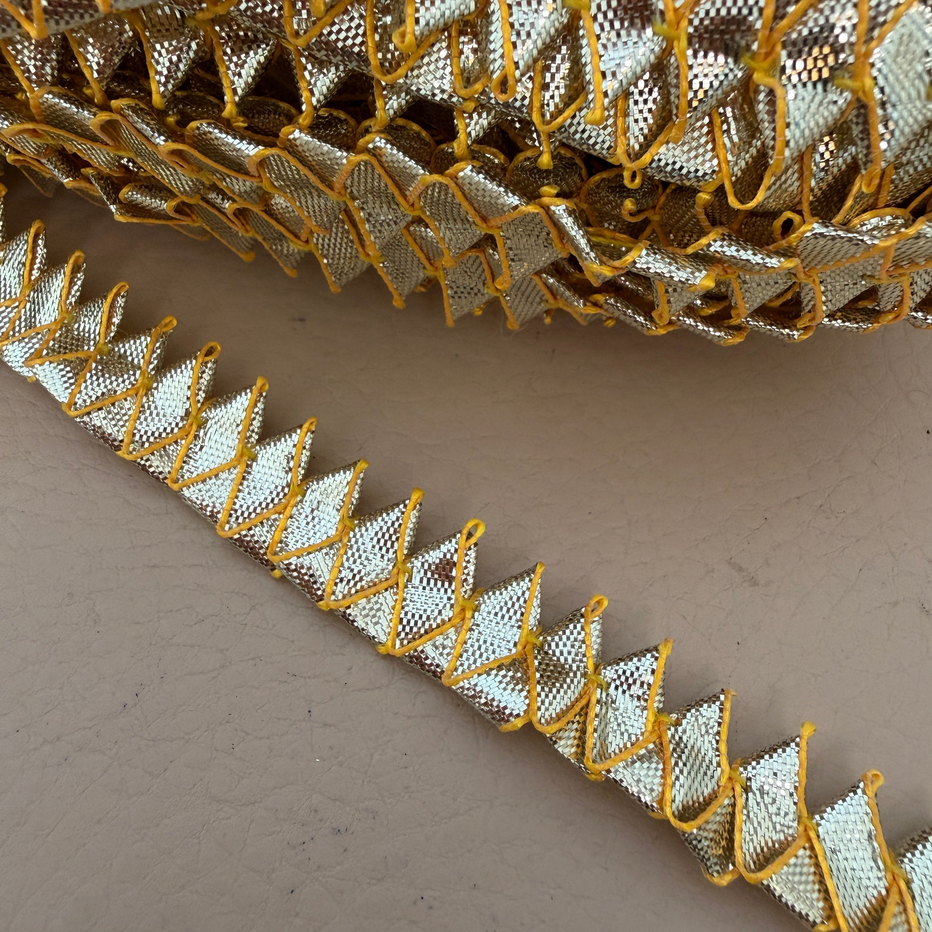 Close-up of gold and silver metallic lace on a beige background
