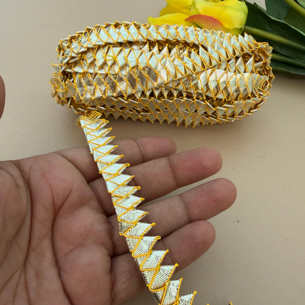 Decorative gold and white ribbon held by a hand with a blurred background