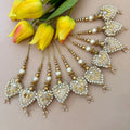 Decorative hair accessories with pearls and gold accents on a beige background with yellow tulips.
