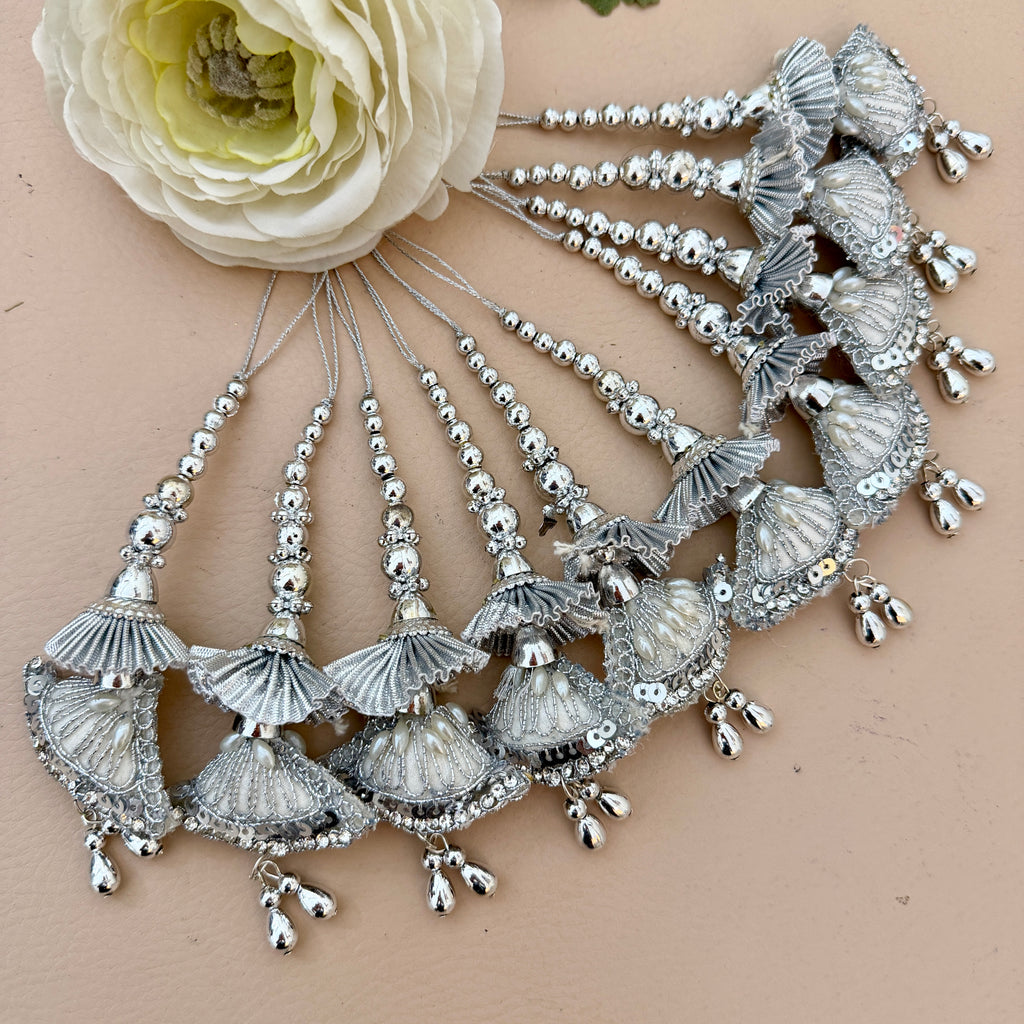 Silver jewelry set with shell-like designs on a beige background