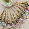 Decorative hair accessories with gold beads and colorful tassels on a neutral background