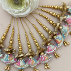 Decorative hair accessories with gold beads and colorful tassels on a neutral background