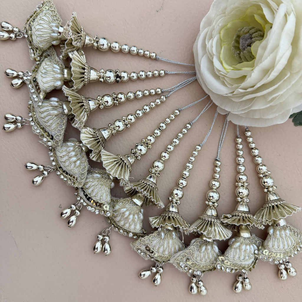 Decorative hairpiece with shell-like elements and beads on a beige background with a white flower.