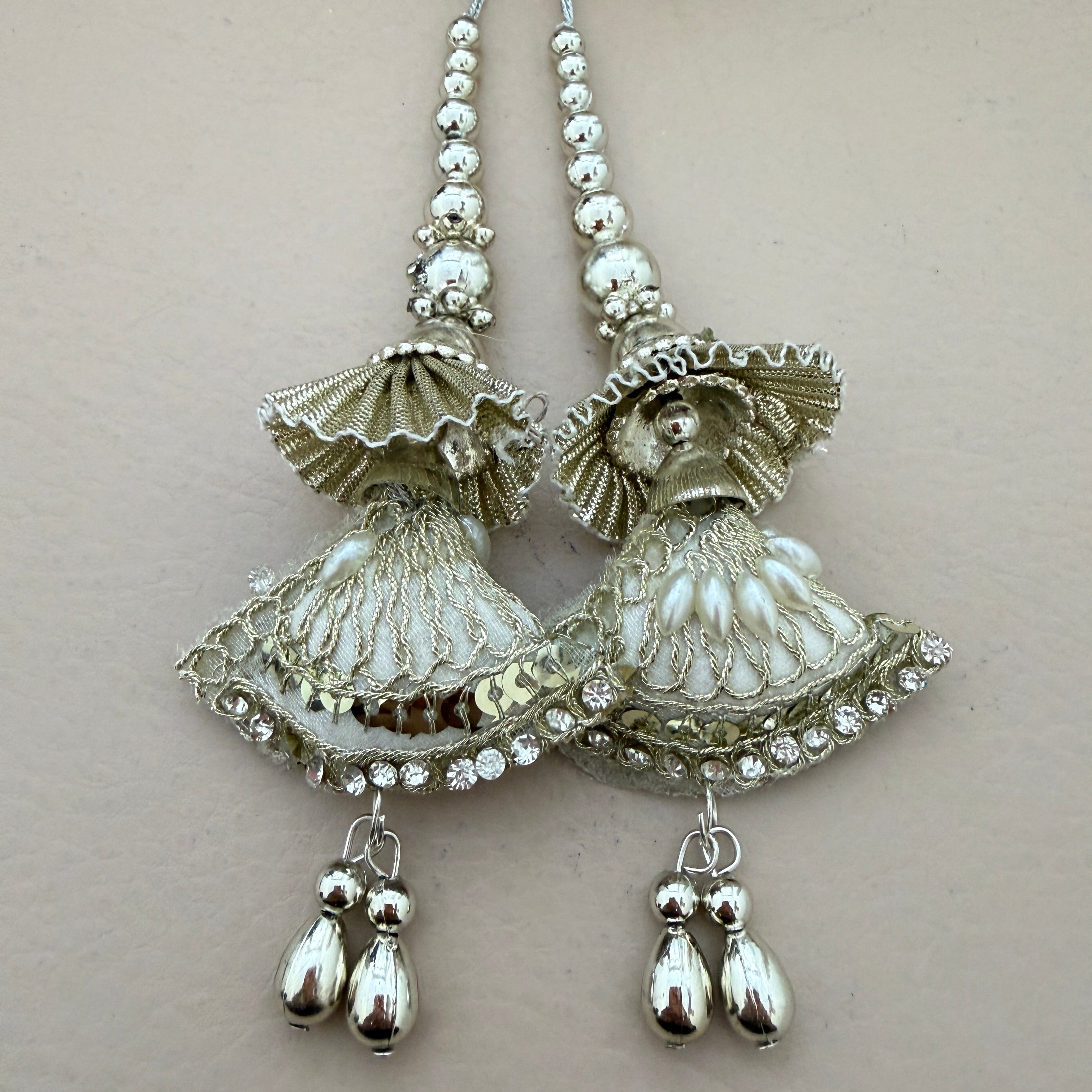Pair of silver earrings with intricate designs on a light gray background