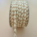 Spool of brown and beige braided cord on a plain background
