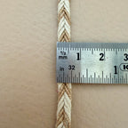 Measuring tape showing the thickness of a braided rope on a beige background