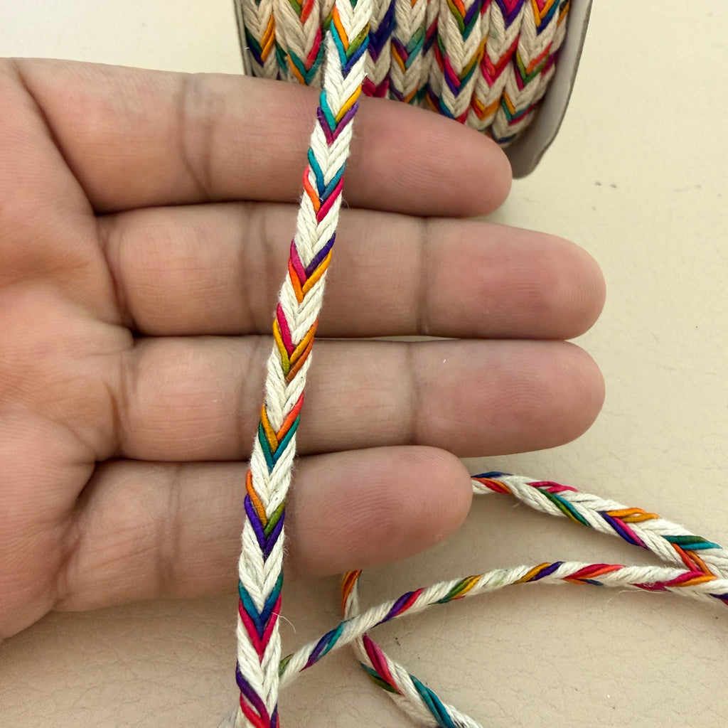 Close-up of a hand holding a colorful braided cord.