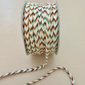Spool of multicolored braided cable on a beige background