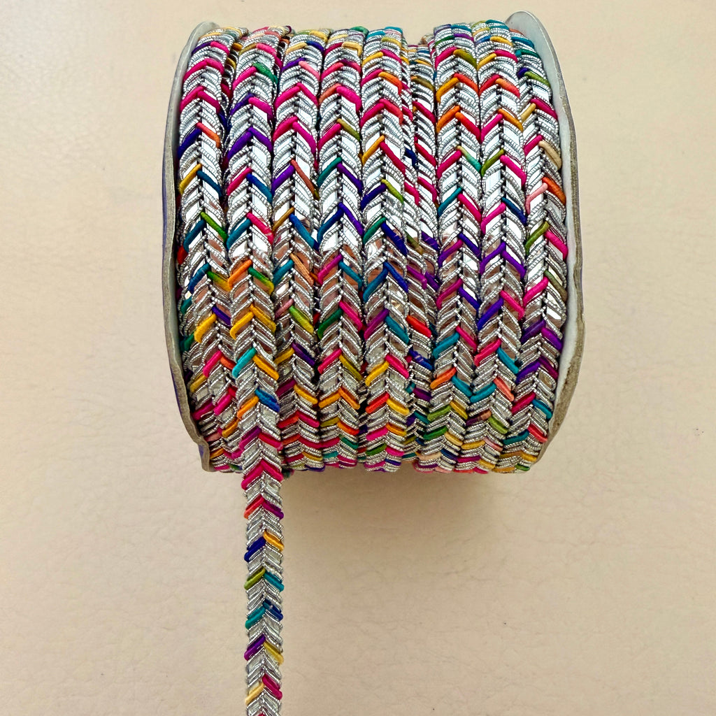 Spool of colorful braided rope on a beige background