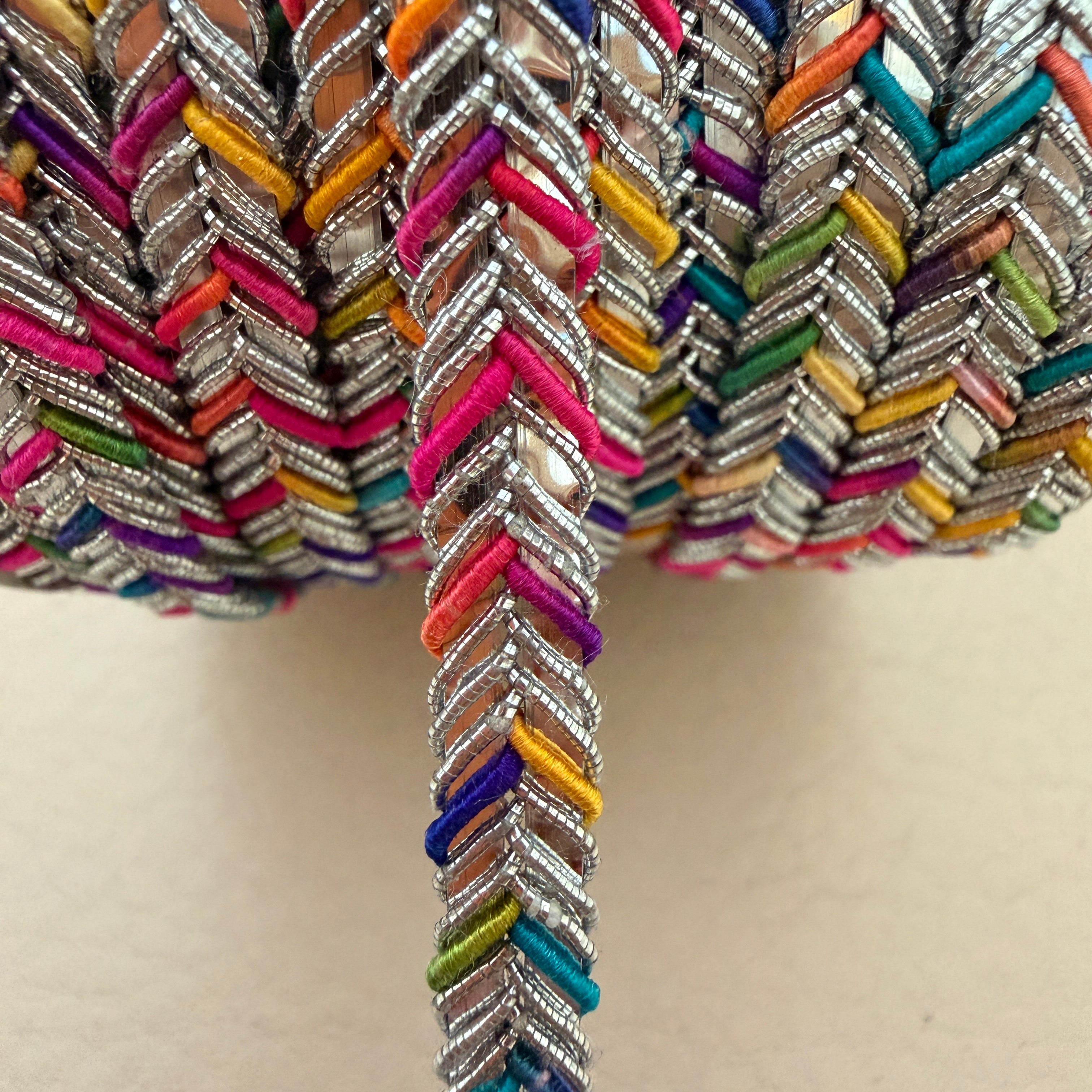 Close-up of colorful braided trim on a beige background
