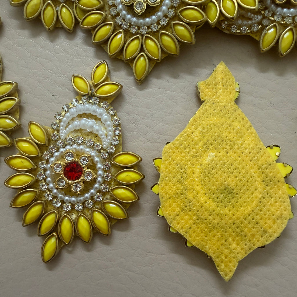 Decorative yellow and white jewelry piece on a beige background
