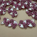 Decorative fabric patches with maroon and white design on a beige background