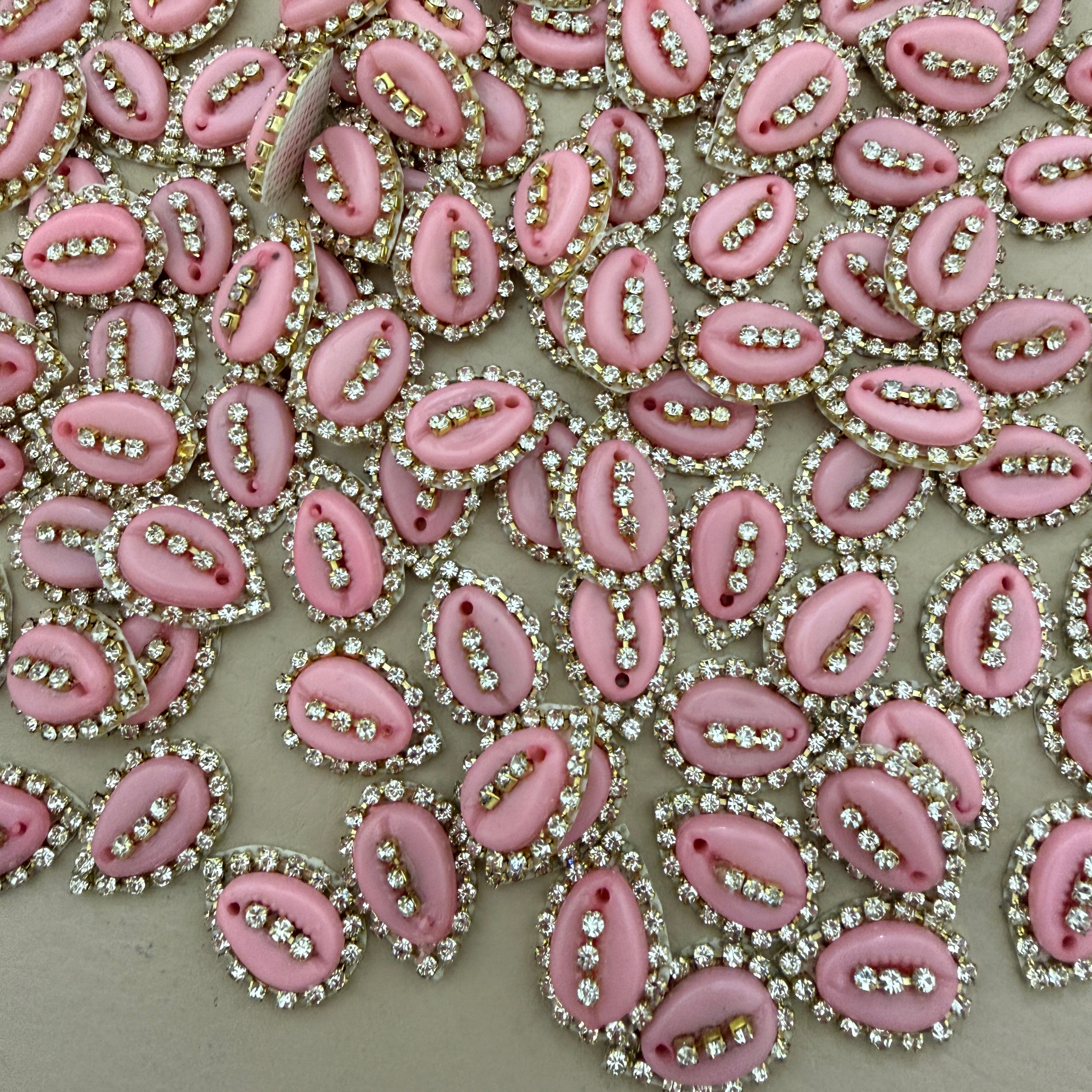 Pink embellishments with rhinestones on a beige background