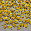 Yellow embellishments with rhinestones on a light gray background