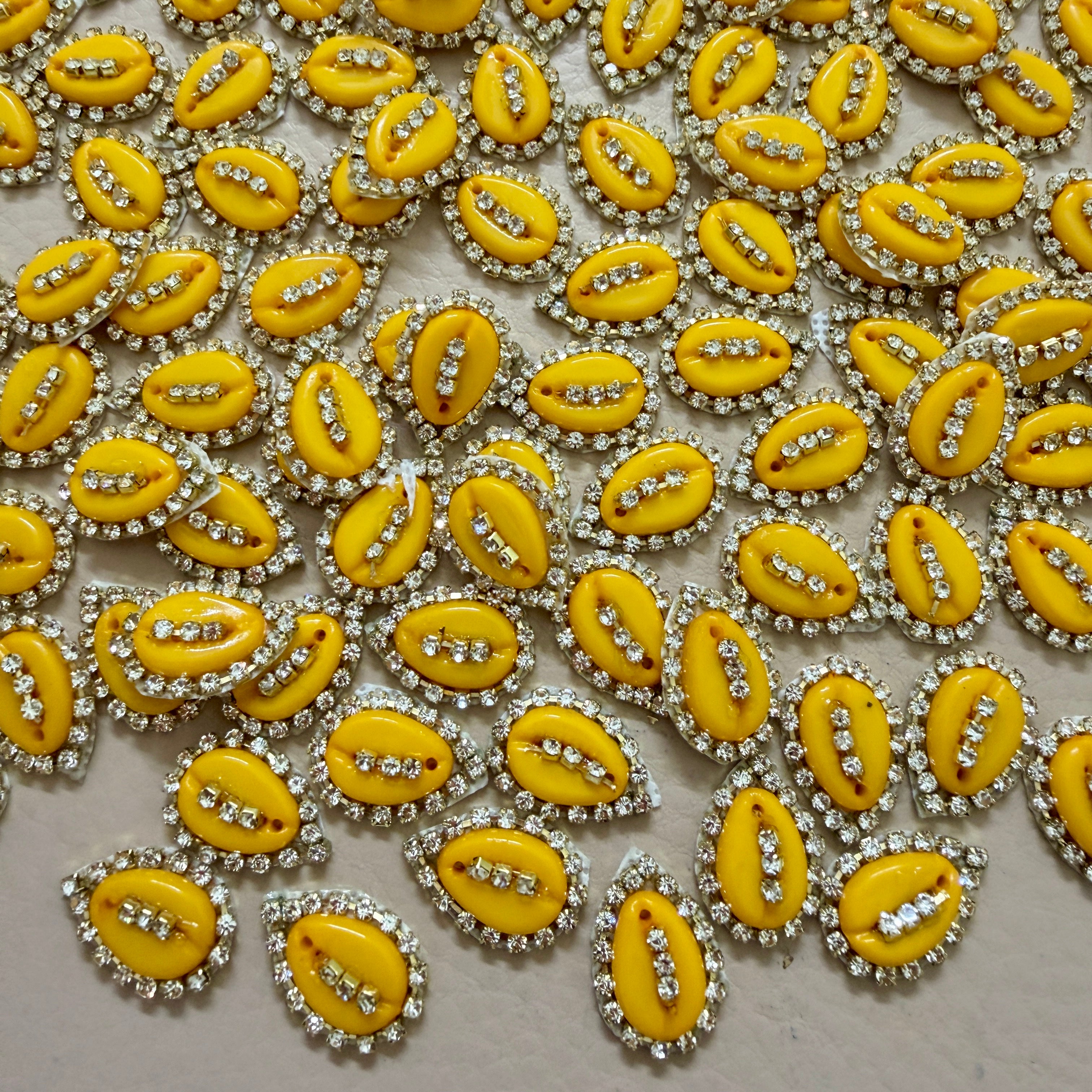 Yellow embellishments with rhinestones on a light gray background