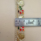 Decorative lace trim with colorful beads and a ruler for scale on a beige background