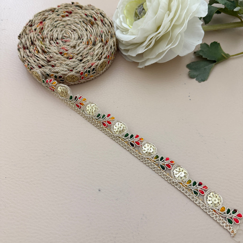 Decorative ribbon with floral pattern on a light surface with a white flower.